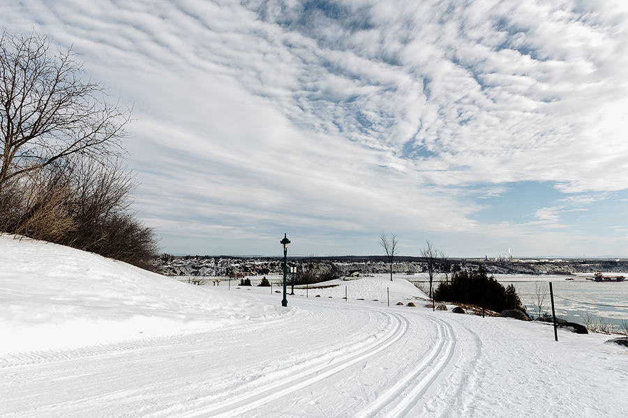 Pistes de ski de fond tracées sur les plaines d'Abraham offrant une vue sur le fleuve Saint-Laurent. Cross-country ski trails on the Plains of Abraham offering a view of the St. Lawrence River.