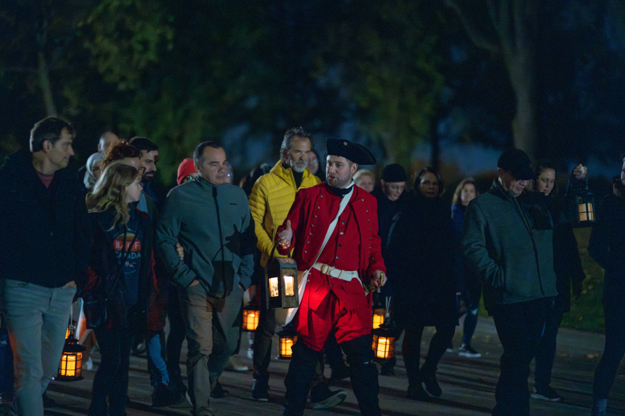 Photo de visiteurs marchant à l'extérieur avec des lanternes