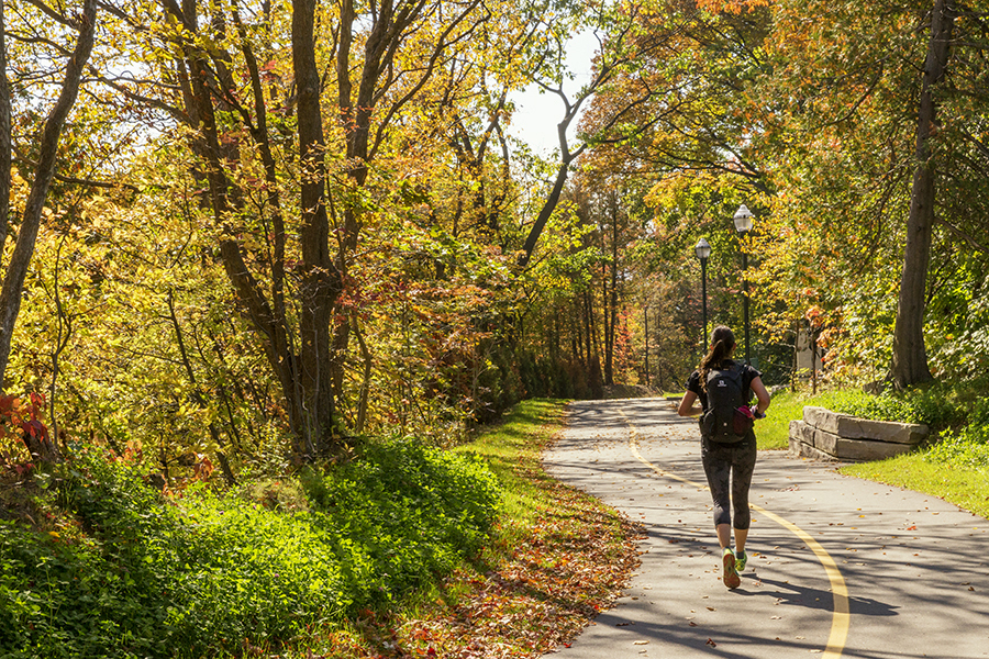 Une femme courant sur une piste multifonctionnelle en nature sur le plaines d'Abraham à l'automne.
A woman running on a multifunctional trail in nature on the Plains of Abraham in the fall.
