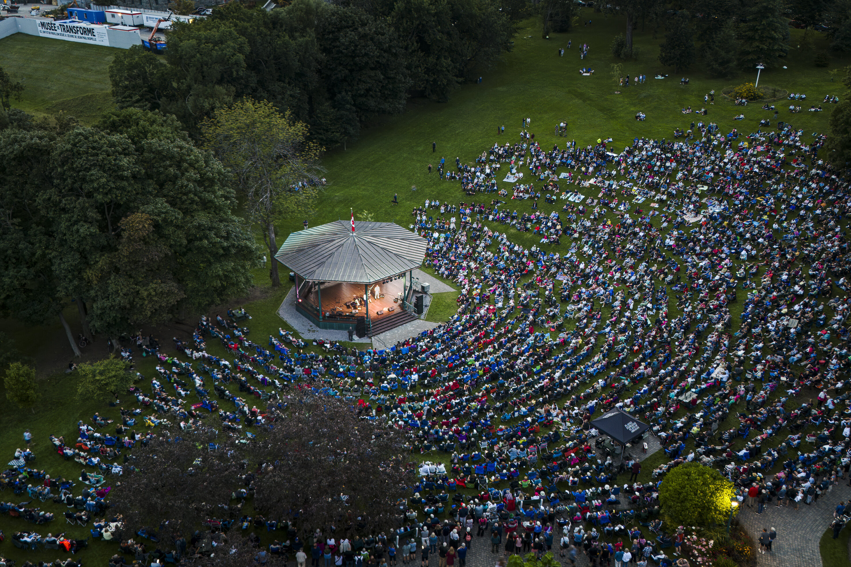 Vue arienne d'un spectacle extérieur au Kiosque Edwin Bélanger avec une foule