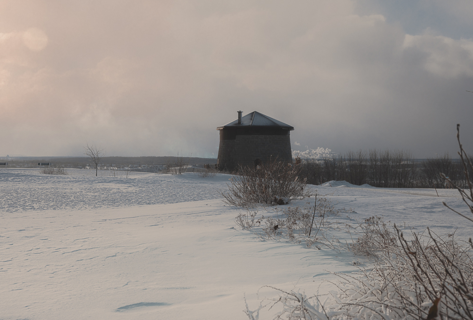 Paysage enneigé des plaines, on y aperçoit la tour Martello 1 en arrière-plan. Snowy landscape of the Plains, with Martello Tower 1 visible in the background.