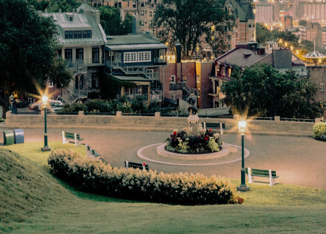 Terrasse Pierre-Dugua-de-Mons en soirée, végétation et maison du Vieux-Québec. Pierre-Dugua-de-Mons Terrace in the evening, with vegetation and a house from Old Quebec.