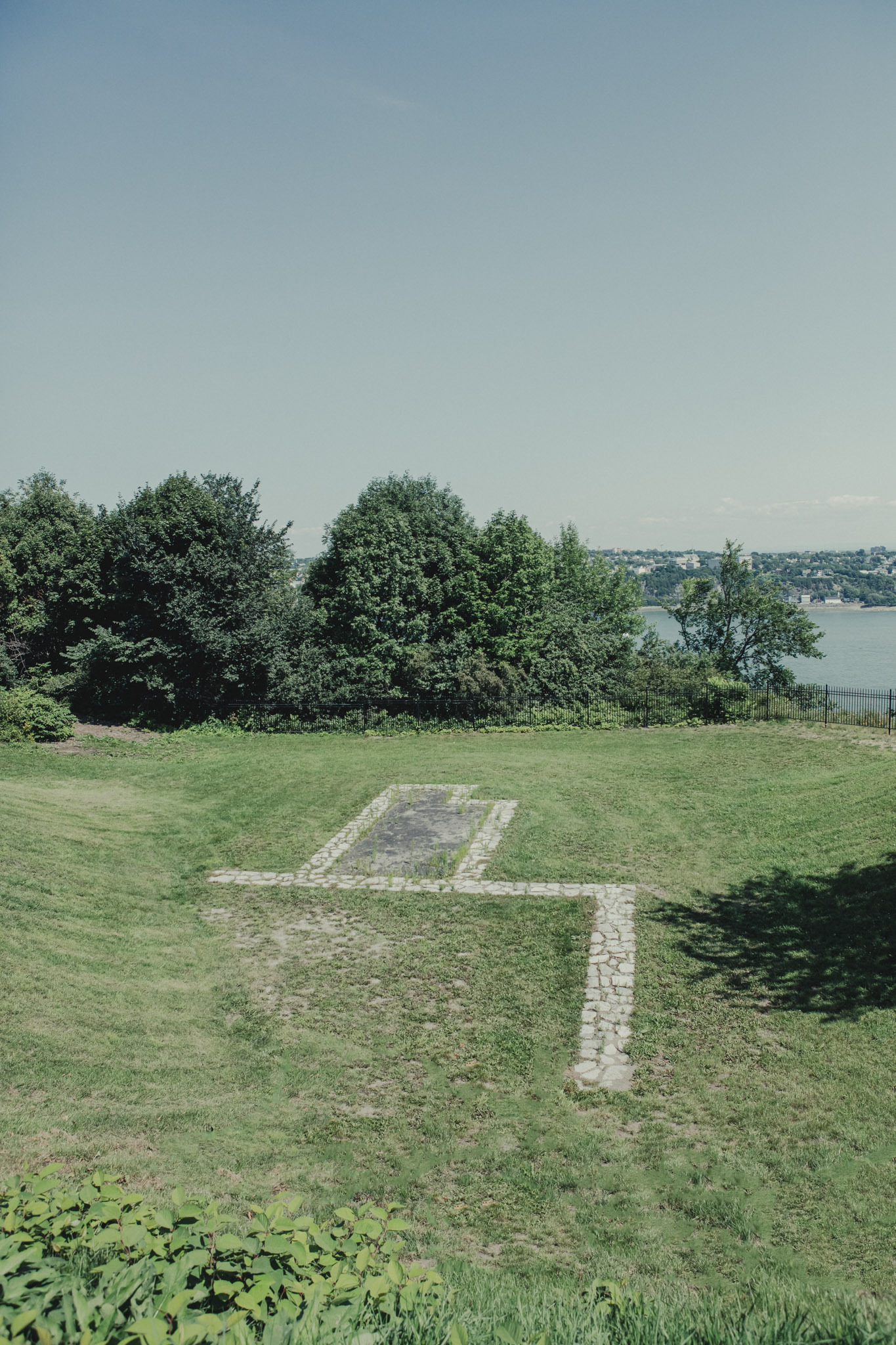 Vestiges du blockhaus historique de Québec avec vue sur le fleuve et la ville en arrière-plan. Ciel dégagé.