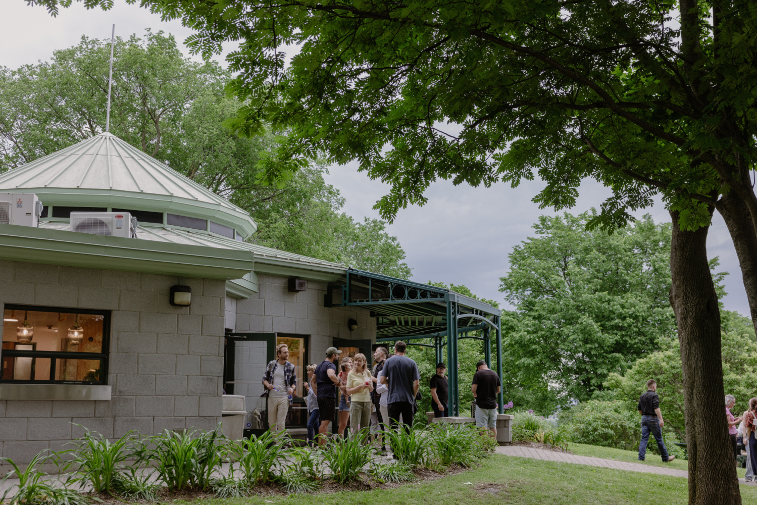 Des visiteurs sont devant le bâtiment du Café Maison Smith.
Visitors are standing in front of the Maison Smith Café building.