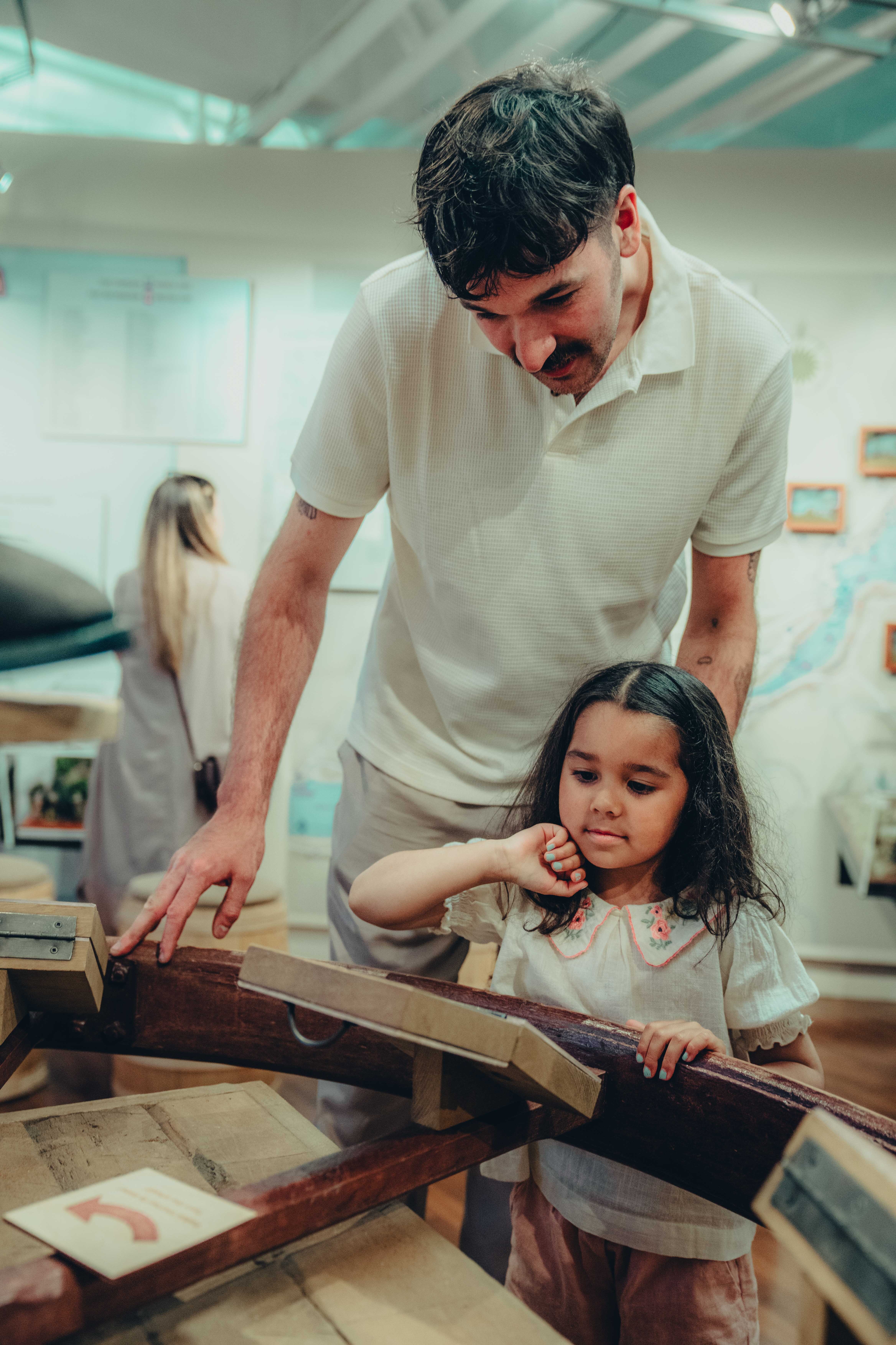 Un père et sa fille contemplant des pièces d'une exposition au Musée des plaines d'Abraham. A father and his daughter admiring pieces of an exhibit at the Plains of Abraham Museum.